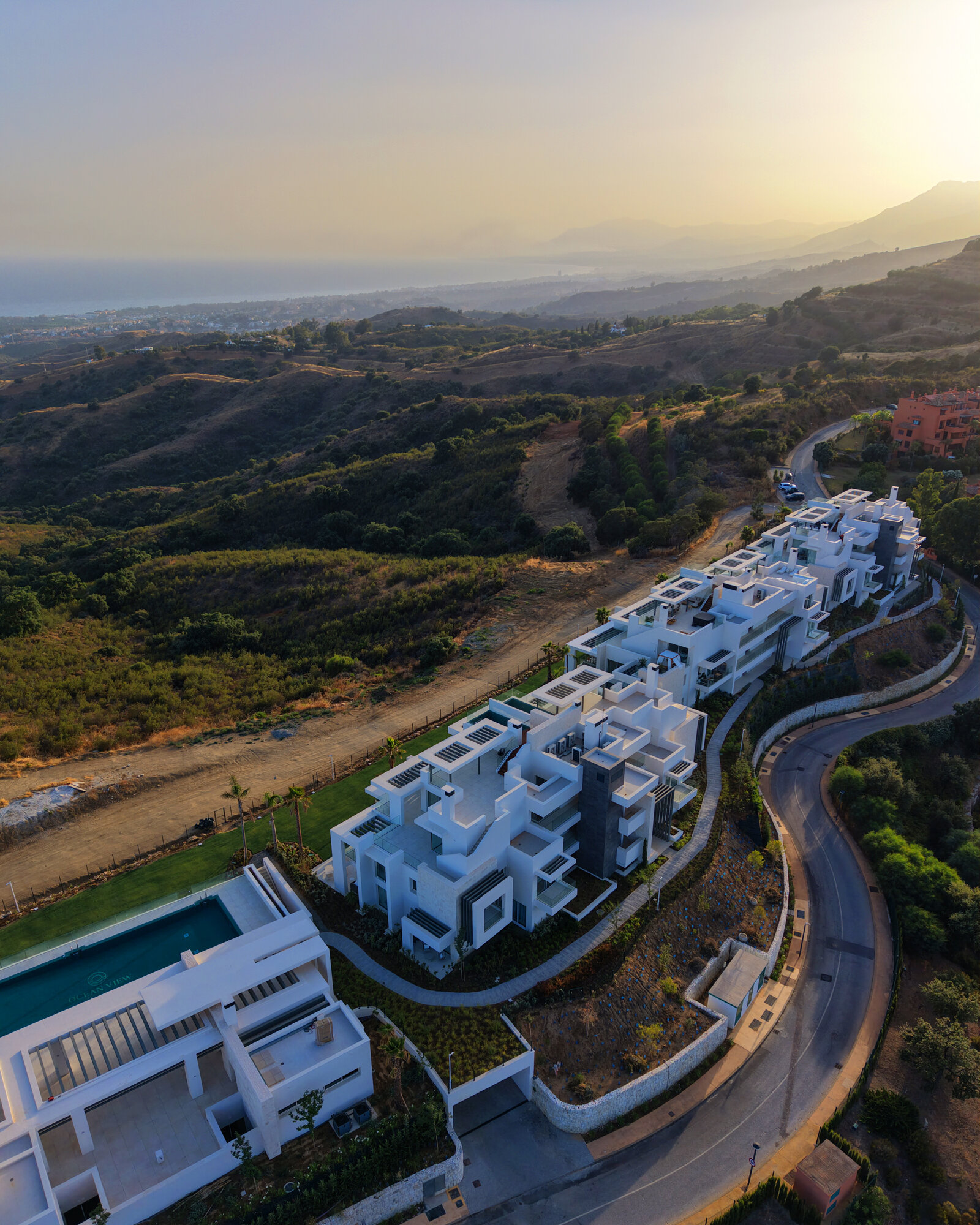 Aerial view of a hillside development at sunset