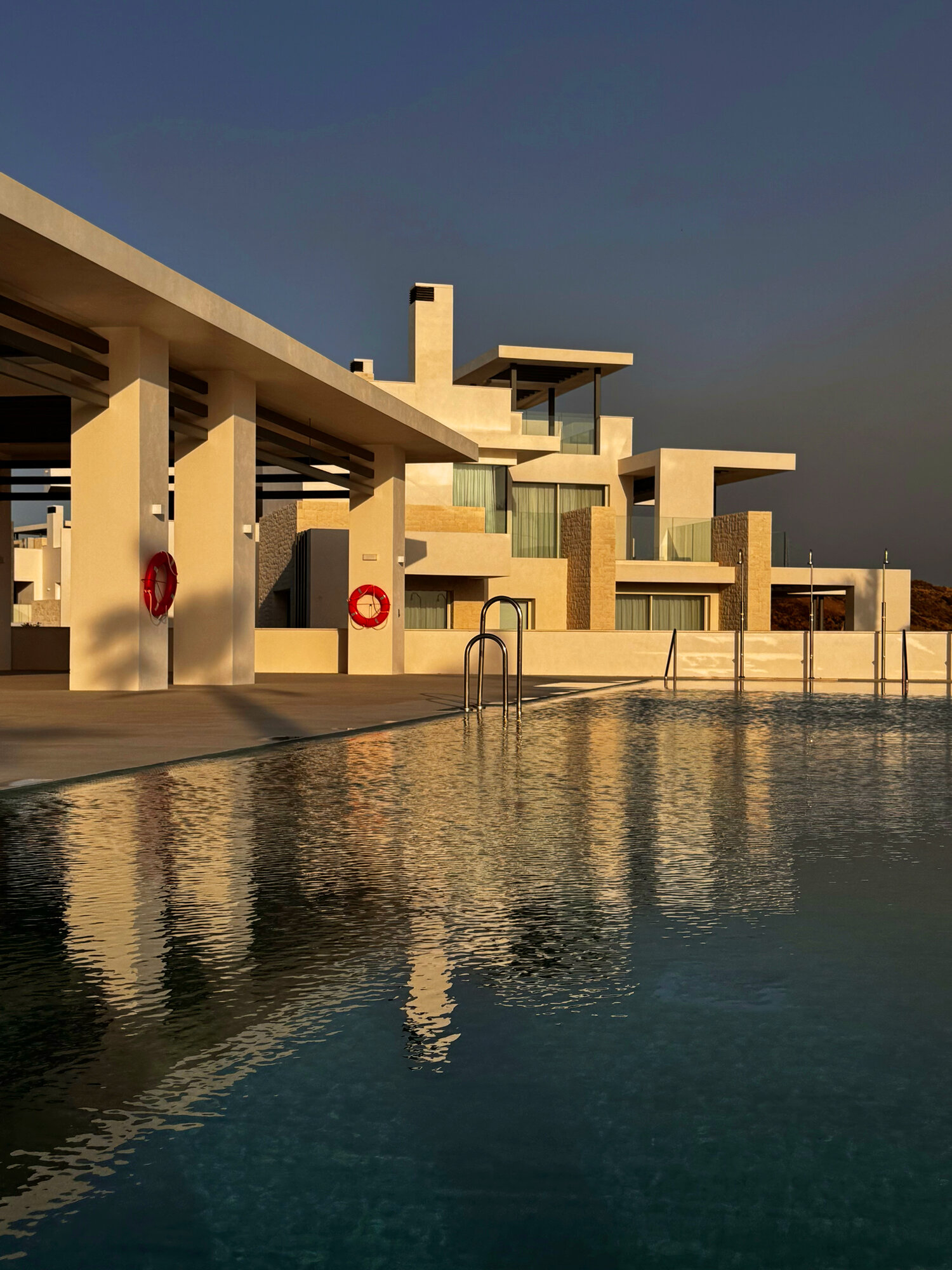 Villa reflected in an infinity pool at golden hour