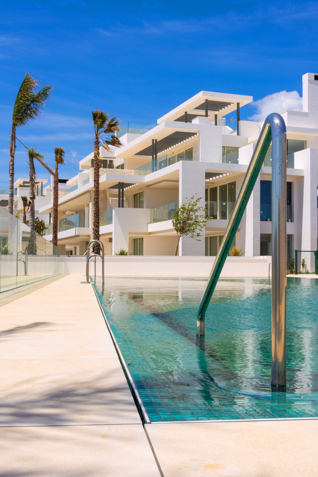 Pool steps and modern villas with palm trees
