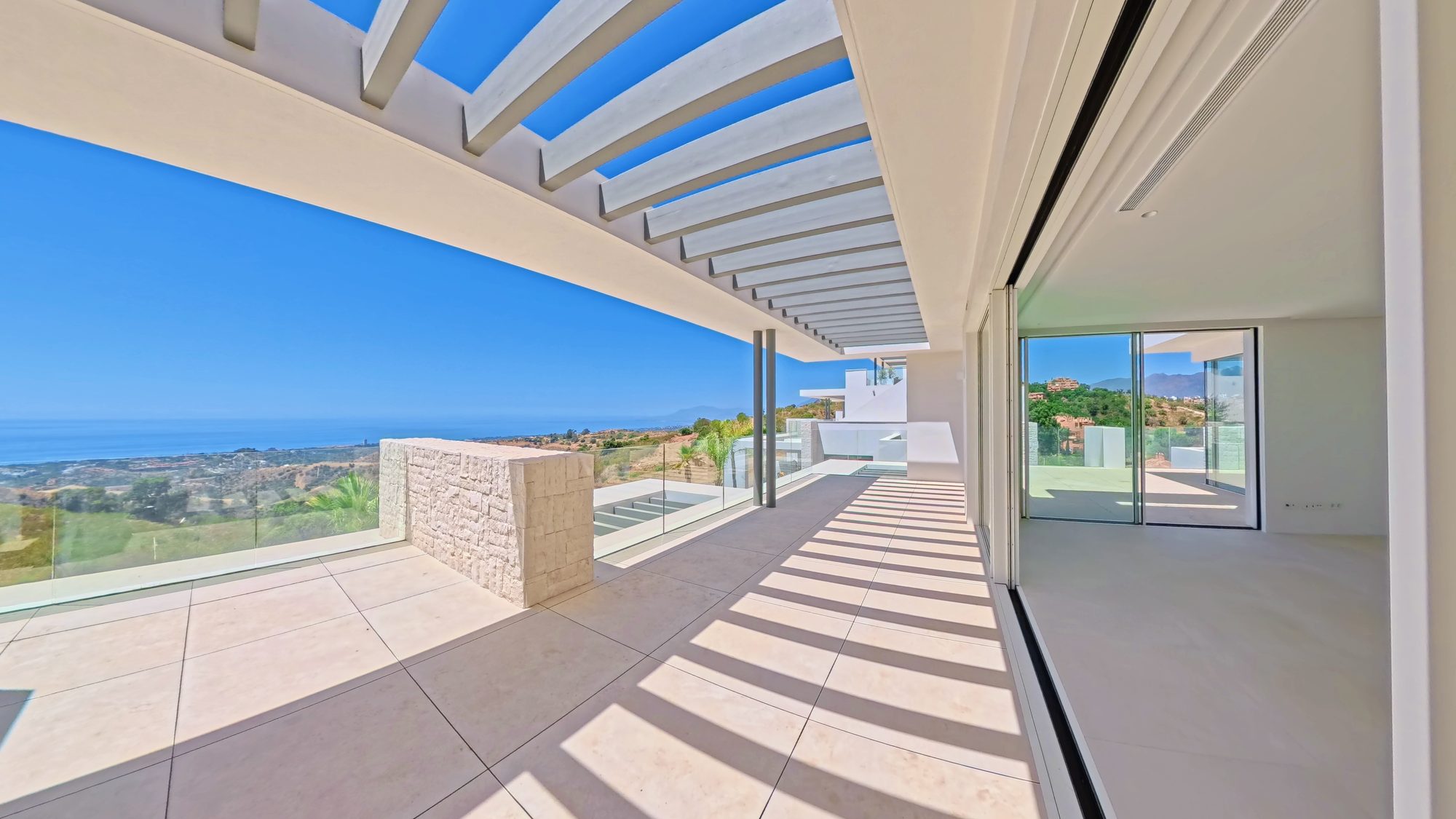 Open-plan interior with floor-to-ceiling glass and sea view